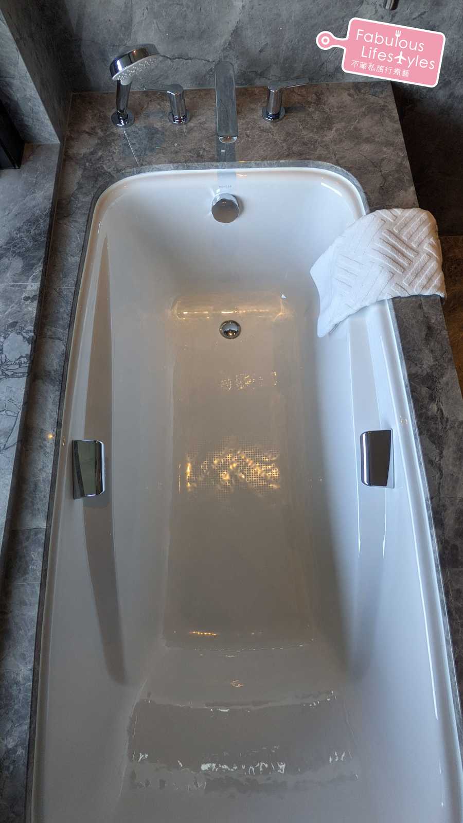 浴缸兩邊附有可撐力起身的金屬扶手